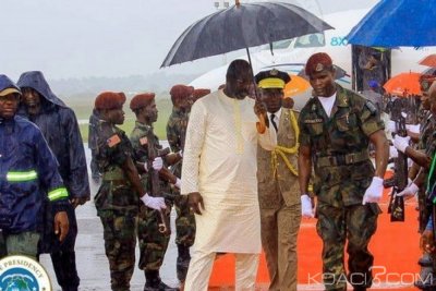 Liberia :  Arrivé sous une pluie, Weah sert un soldat venu pour l'abriter